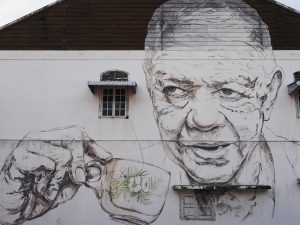 A mural of a man sipping an Ipoh White Coffee.