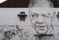 A mural of a man sipping an Ipoh White Coffee.